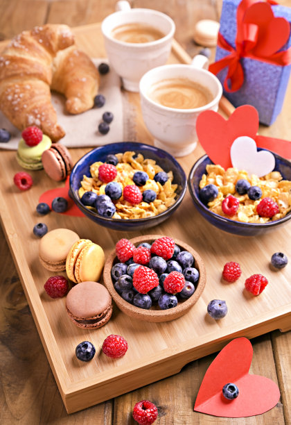 早晨咖啡。芳香的咖啡，什锦麦片和甜糕点的浪漫早餐。早上吃浆果和卡布奇诺的健康食物。高质量的照片图片下载