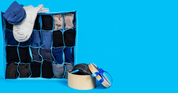 男式多色袜子和腰带，包装在一个蓝色背景的包装里。礼物。图片下载