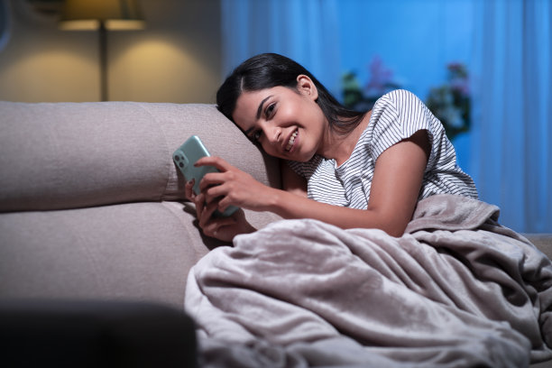 年轻女子在家沙发上坐着，库存照片图片下载