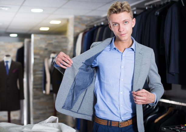 成年男子在商店试穿西装外套图片下载