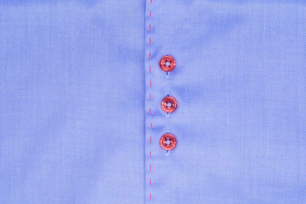 特写的蓝色时尚衬衫与一个红色的扣子。昂贵的品牌衬衫图片下载