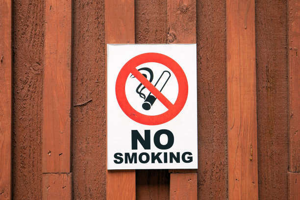 禁止吸烟。棕色木墙上的警告标志图片下载