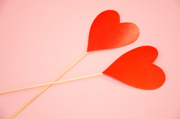 两颗心躺在粉红色的背景上。情人节的概念图片下载