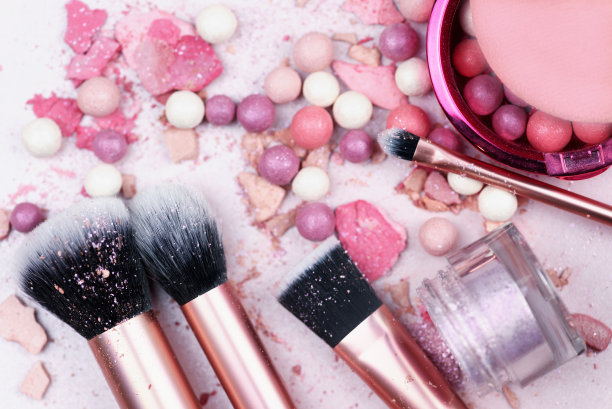 粉色的化妆刷和化妆品在粉红色的背景。图片下载