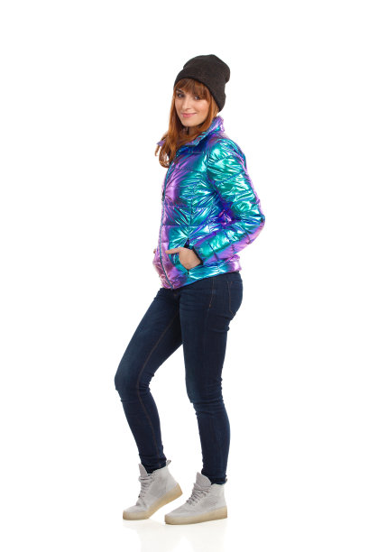 美丽的年轻女子在冬天的衣服是站和微笑。图片下载