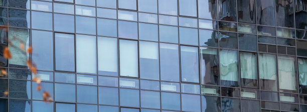 摘要商业现代城市城市未来建筑背景。房地产概念，动态模糊，高层摩天楼立面的玻璃反射，色调蓝色的画面与散景图片下载