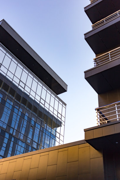 摘要商业现代城市城市未来建筑背景。房地产概念，动态模糊，高层摩天楼立面的玻璃反射，色调蓝色的画面与散景图片下载