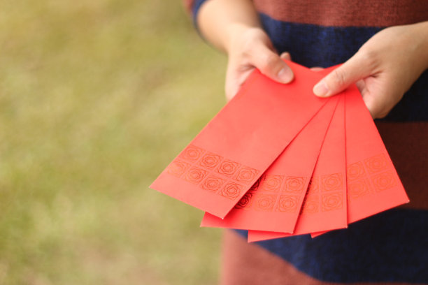 一个拿着红包的亚洲女人。图片下载