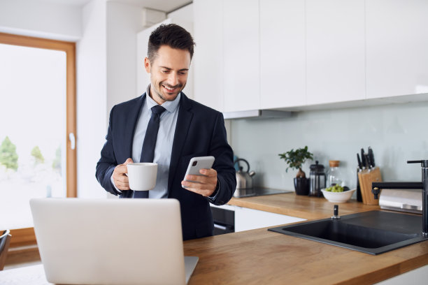 商人站在厨房里用手机素材图片