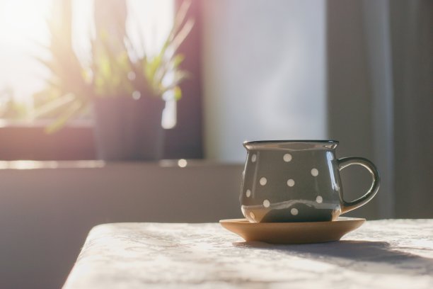桌上放着一杯热茶，温馨的室内背景图片下载