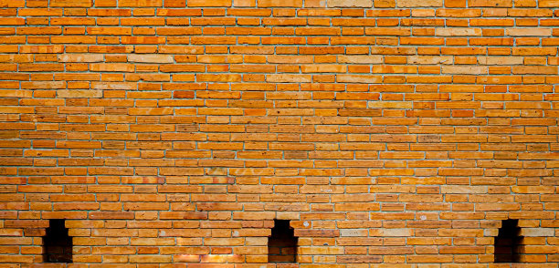 背景图片的橙色砖墙在一个阳光明媚的日子。图片下载