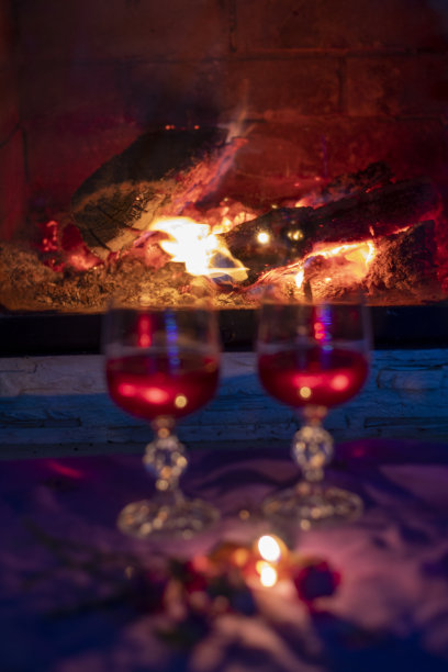 模糊的两杯红酒，靠近壁炉，傍晚，模糊的背景图片下载