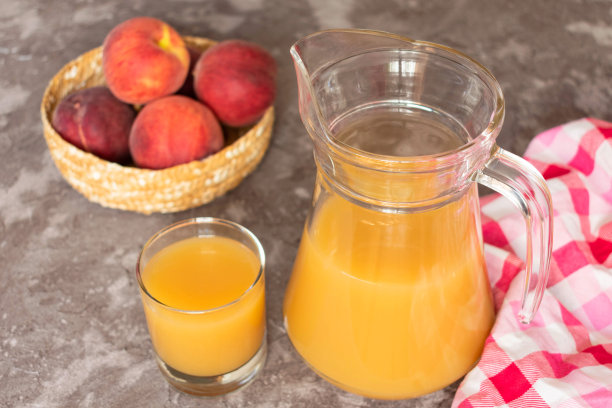 灰色背景上的水蜜桃汁。特写镜头。图片下载