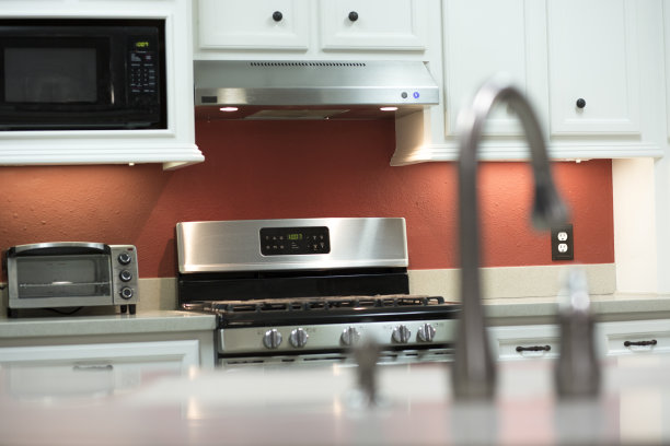 白色和明亮的厨房与红色的强调墙。图片下载