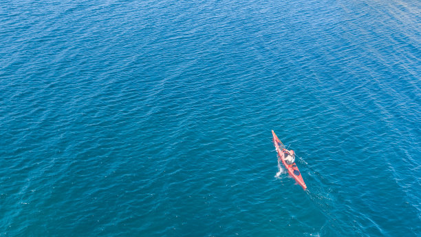 碧绿清澈海水中红色运动独木舟航拍照片图片下载