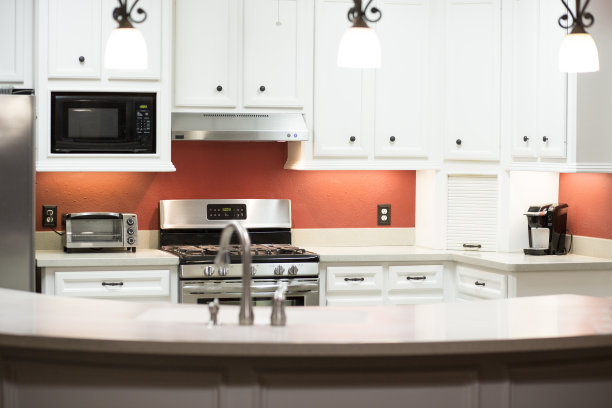 白色和明亮的厨房与红色的强调墙。图片下载