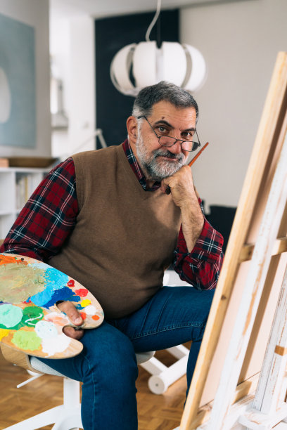 一个男人在他的家里画画图片下载