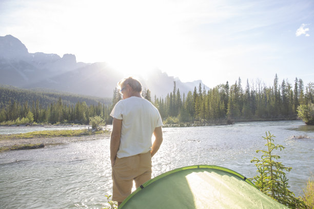 一个人在河上的帐篷外迎接初升的太阳图片下载