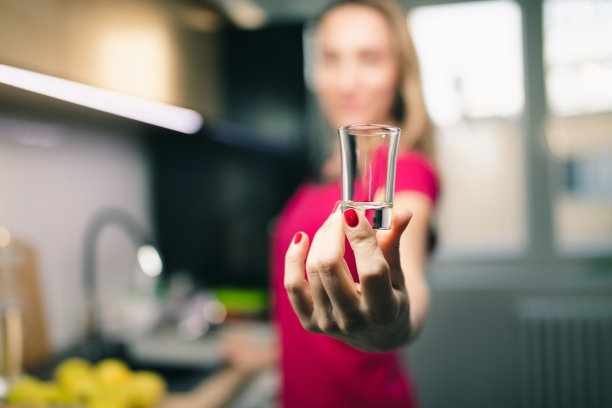 厨房里拿着小酒杯的女人的手图片下载