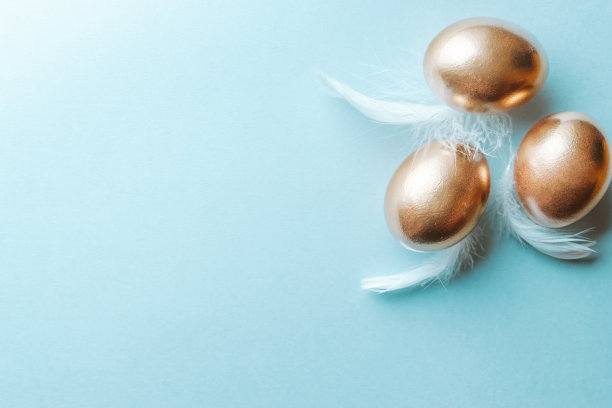 金色复活节彩蛋与白色羽毛在淡蓝色背景在快乐复活节装饰。春假俯视图概念。图片下载