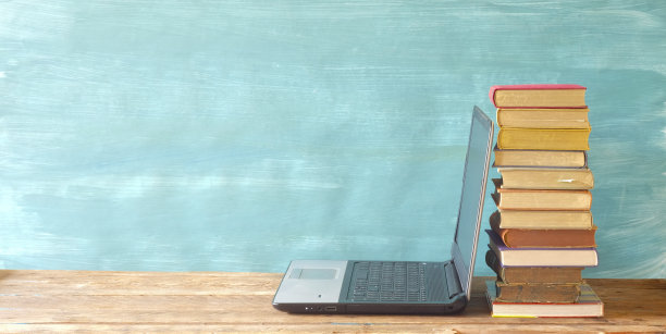 堆叠的书籍和笔记本电脑，电子书阅读器。电子书籍，电子学习，在线教育，家庭办公概念。免费空间图片下载