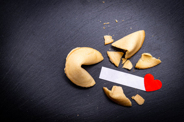 幸运饼干的背景是黑色的石头和一个小红心。图片下载