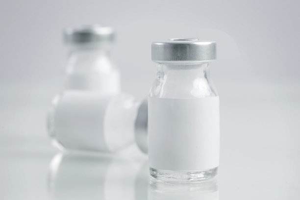 近距离图像的疫苗或注射瓶与空白白色标签。瓶瓶模型。科学、疫苗、免疫、保健和医学概念。图片下载