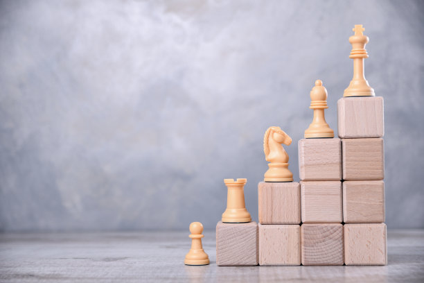木立方体以楼梯的形式堆放在木桌上。理念发展，成长，老板，最好。与棋子图片下载