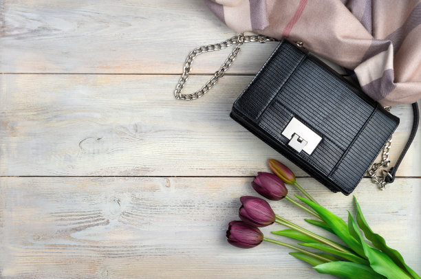 郁金香，包包，围巾，在浅色的木质背景上。顶部视图与空间复制。图片下载