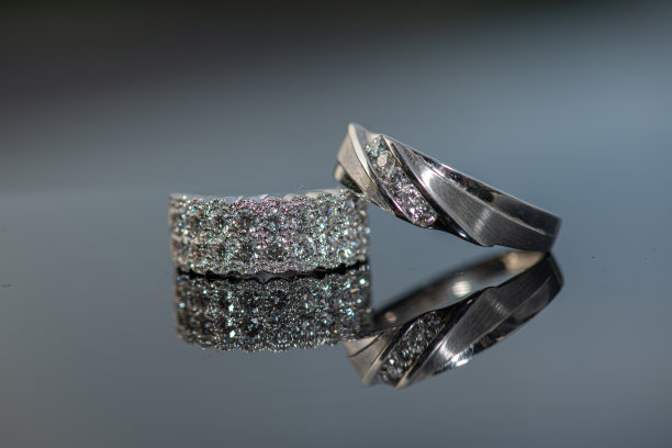 玻璃反射面上，新娘钻戒上的白金新郎结婚戒指图片下载