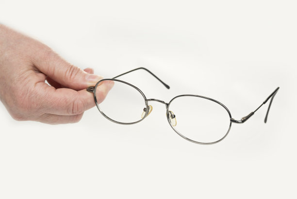 手拿着屈光度眼镜看书图片下载