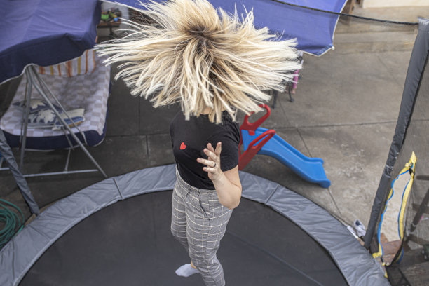 活泼的女孩在户外蹦床上跳得很高图片下载