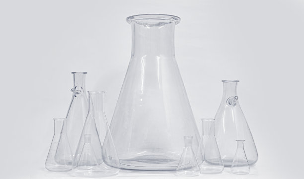 不同大小的玻璃烧杯在化工重的背景下冷色调的光。图片下载