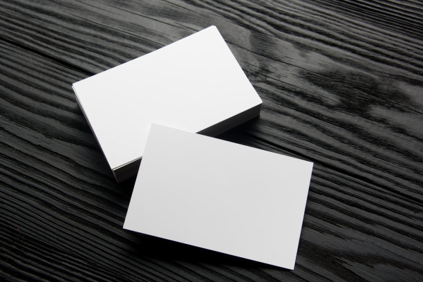 黑色木质背景的空白名片。企业文具，品牌模型。创意设计师的办公桌。平的。文本复制空间图片下载