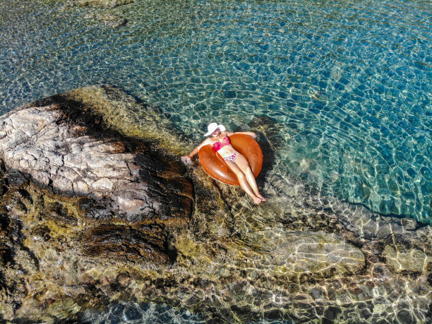 美丽的女人在海上的充气床垫上休息。图片下载