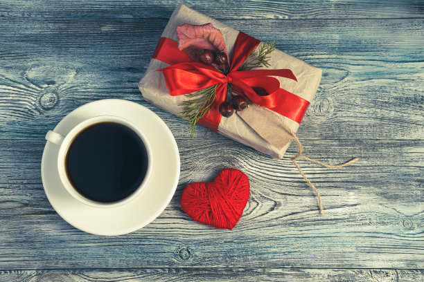 一份礼物，咖啡和一颗心在灰蓝色的木制背景上的节日构图图片下载