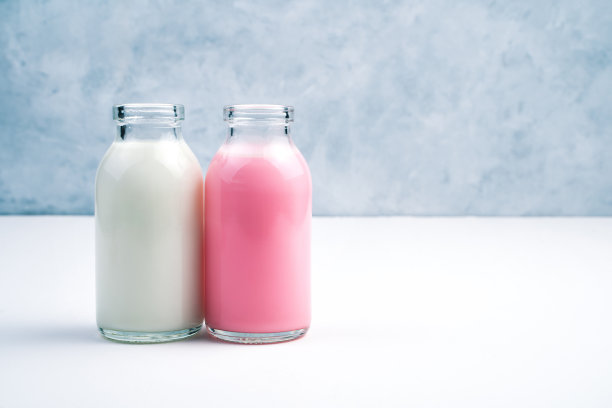 粉红色和白色的瓶子奶昔，白色和灰色的背景图片下载