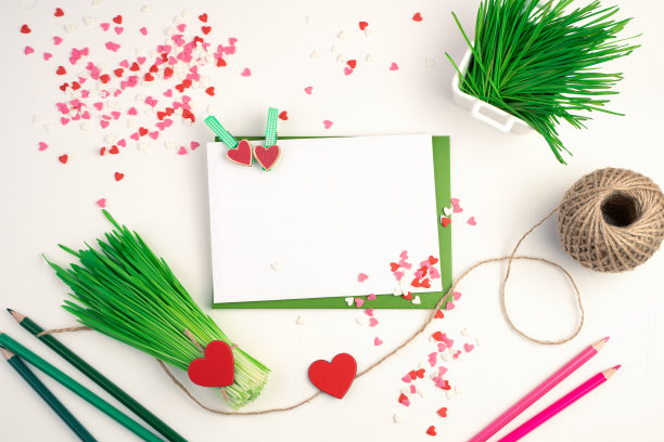 一束绿色的麦芽菜，信封，铅笔和心在一个明亮的背景图片下载