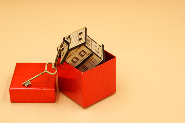 古董屋钥匙和家庭钥匙圈内的红色礼盒孤立在黄色背景和复制空间-新家，礼物的概念图片下载