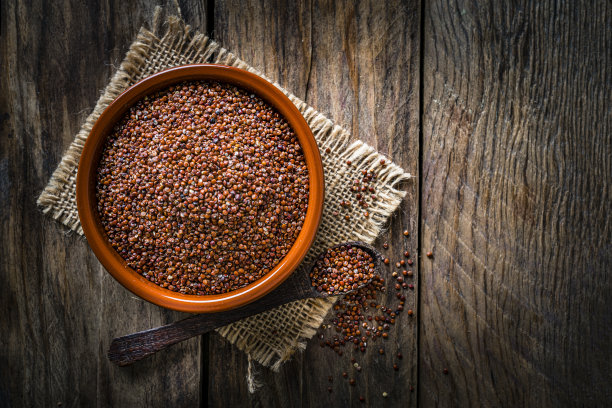 红色的藜麦种子放在一个碗里，放在质朴的木桌上。本空间图片下载