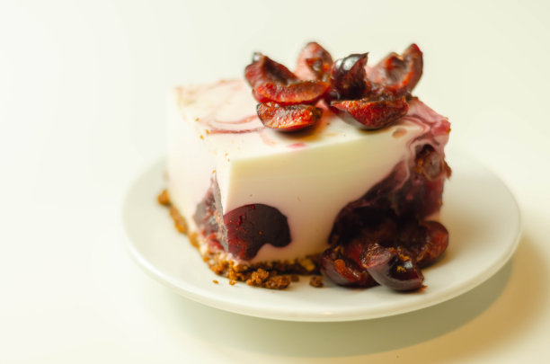 日式芝士蛋糕，配樱桃酱和新鲜樱桃，以白色为背景图片下载