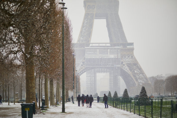 大雪纷飞的一天，人们从巴黎埃菲尔铁塔前走过图片下载