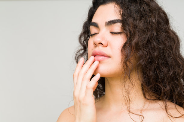 一个闭着眼睛涂唇膏的女人图片下载