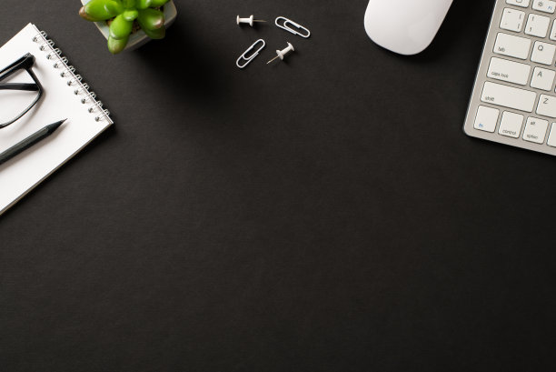 办公设备的Flatlay照片键盘、鼠标、别针、回形针、绿色植物、螺旋抄写本、眼镜和铅笔孤立的黑色背景图片下载