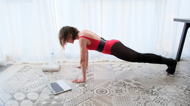 一个坐在电脑前做俯卧撑的女人图片下载