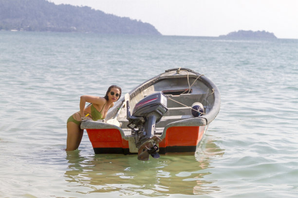 穿着泳衣的女人在海滩上玩船图片下载