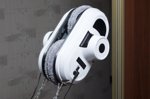 吸尘器机器人在清洗房间的玻璃镜子。机器人助手在家里清洁窗户。图片下载