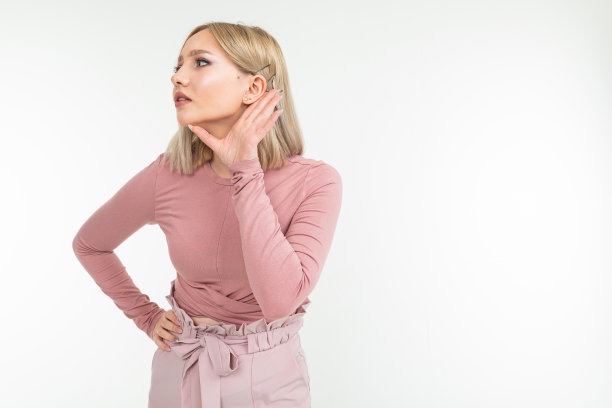 一个金发女孩无意中听到了一段对话，背景是白色的，有复印空间图片下载