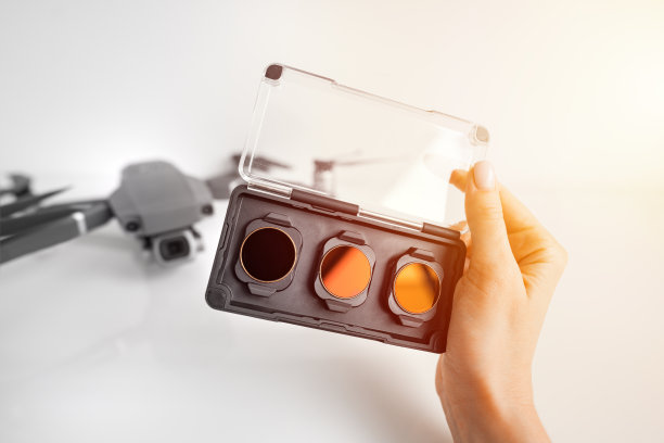 女人拿着ND过滤器和偏振光过滤器设置无人机。无人机摄像头的滤镜。图片下载