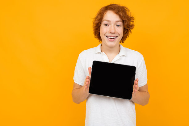 白人男子在白色衬衫显示一个空白的平板屏幕模板在一个黄色的背景与复制空间图片下载